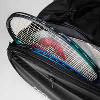 Zwei Tennisschläger in der Seitentasche einer schwarzen Sporttasche, die teilweise mit einem Reißverschluss verschlossen ist.