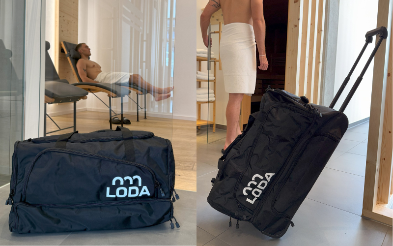 Ein schwarzer LODA-Seesack auf dem Boden und eine Person mit einem Handtuch, die denselben Sack auf Rädern zieht.